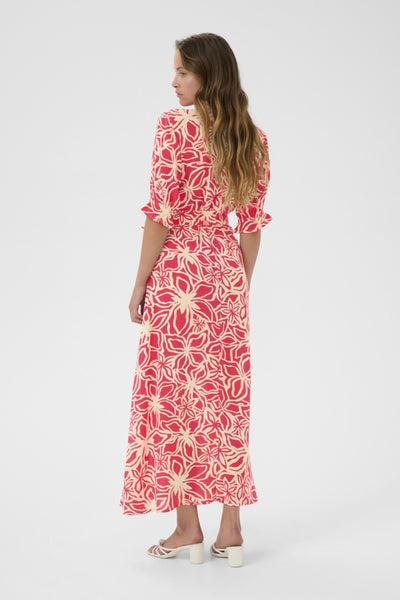 Back view of model wearing this long dress featuring mid length sleeves and matching belt. Model is wearing low heels