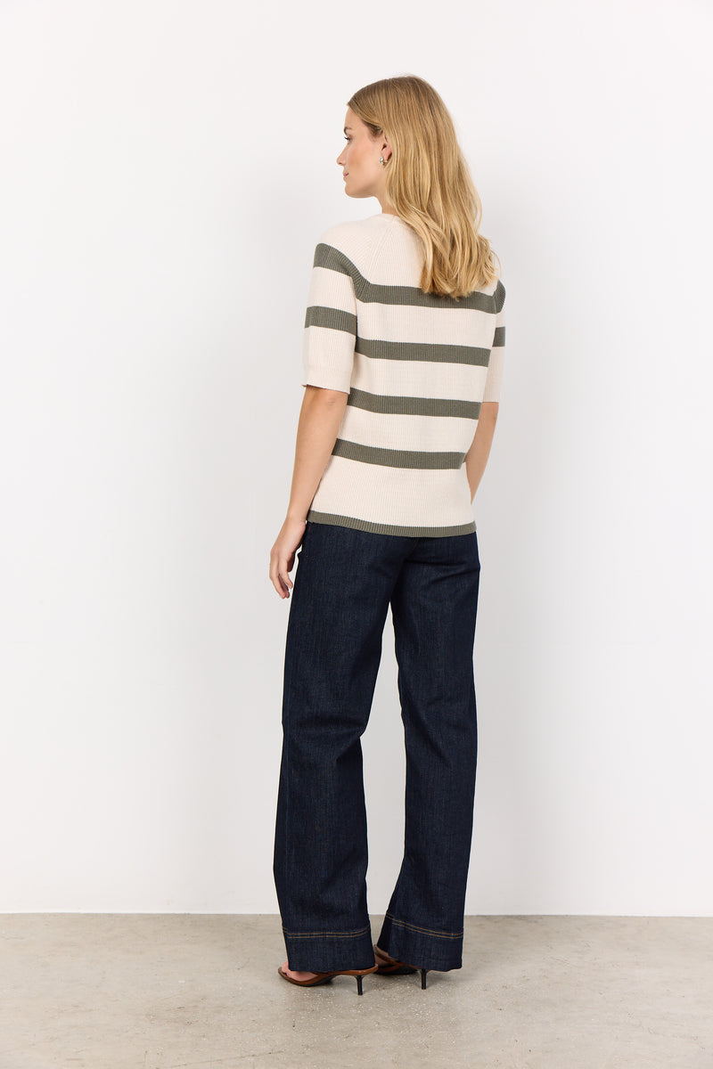 Back view of model wearing soyaconcept short sleeved, round neck Kanita top loose over jeans. This top has a cream background with thick horizontal stripes in khaki 