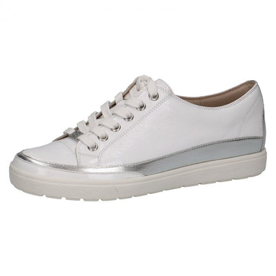 Side view of Caprice white patent leather trainers with laces, silver stripe along base and white rubber sole. 